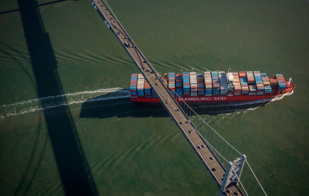 Container Ship Passing Under a Bridge.